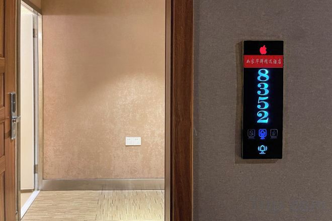 Un passadís amb un panell de control d'ascensor digital que mostra els números de planta 8, 3, 2 i 9.