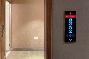 Un pasillo con un panel de control digital de ascensor que muestra los pisos 8, 3, 2 y 9.