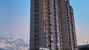 Un immeuble de grande hauteur, doté de nombreux étages et de balcons, avec un ciel dégagé en arrière-plan.