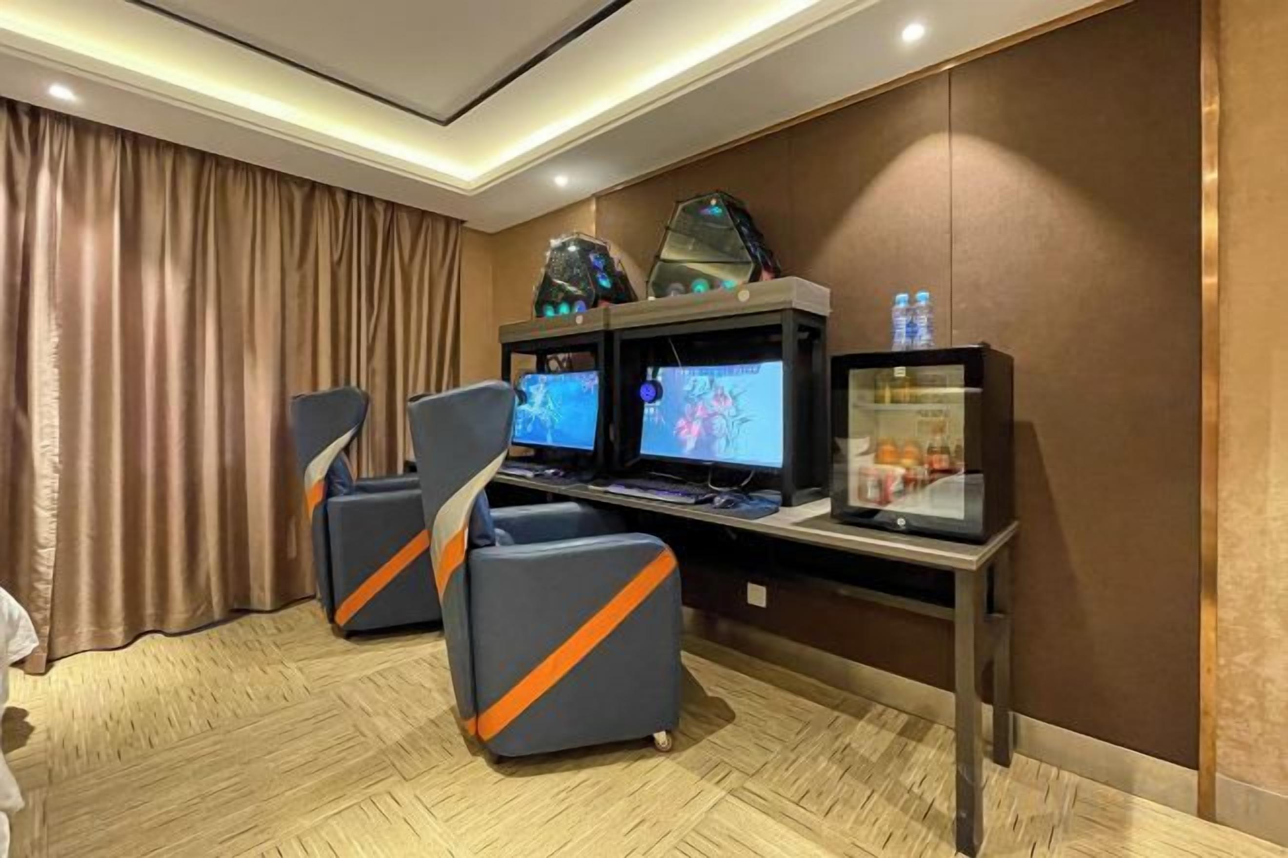 Une salle de jeux équipée de deux fauteuils de jeu, de deux écrans et d’un bureau de jeu.