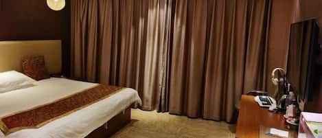Una habitación de hotel con una cama grande, un escritorio con teléfono y un espejo.