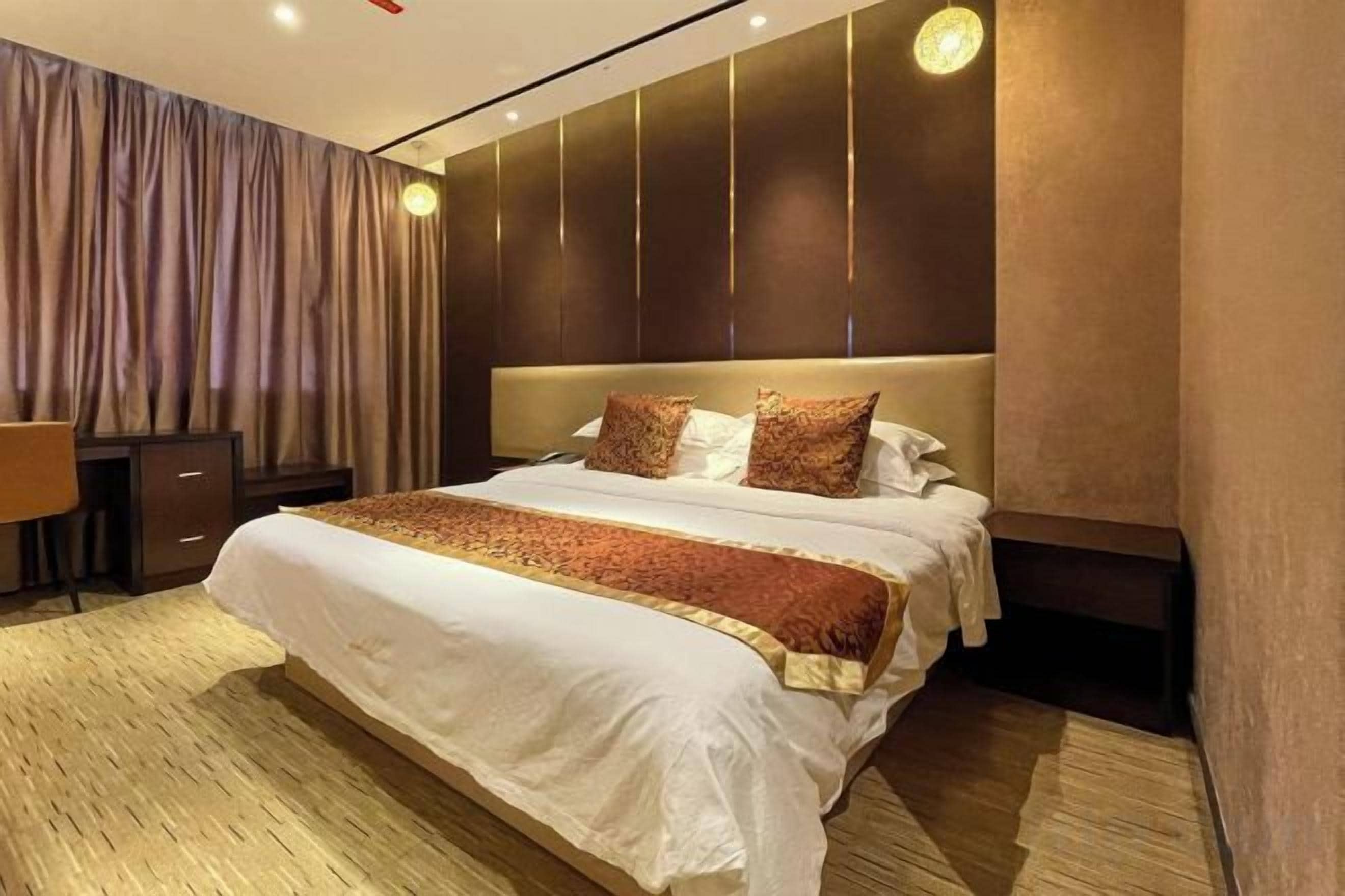Une chambre d’hôtel avec un grand lit, un bureau et une chaise.