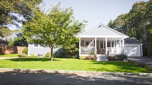 A single-story house with a porch, surrounded by a well-maintained lawn and trees. - Relax by Oak Bluffs Harbor, enjoy your 3-bedroom East Chip retreat (Oak Bluffs)