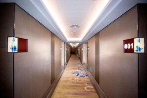A hotel hallway with a carpeted floor, wall-mounted light fixtures, and a number sign indicating room 801. - Nandu Harbour Hotel (Shenzhen)