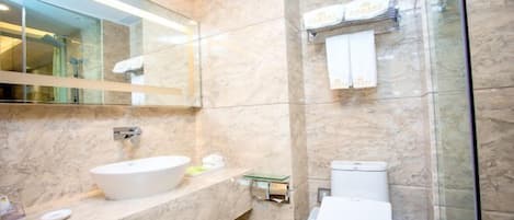Un baño moderno con lavamanos de mármol, inodoro y cabina de ducha de vidrio.