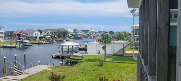 A marina with boats docked, a small boat on a trailer, and a building with a covered area. - Belle Brísa-Canal front Surf City, NC (Surf City)