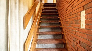 A wooden staircase with alternating carpeted and stone steps, leading to a door at the top. - Holiday Apartment 'Nordsee Ferienwohnung Möwe' with Garden and Wi-Fi (Stedesdorf-Thunum)