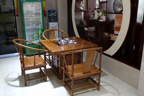 A dining area with a wooden table and chairs, a refrigerator, and a water dispenser.