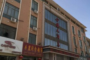 A multi-story building with signage for a hotel and a restaurant. - Jinsui Hotel (Wuwei)