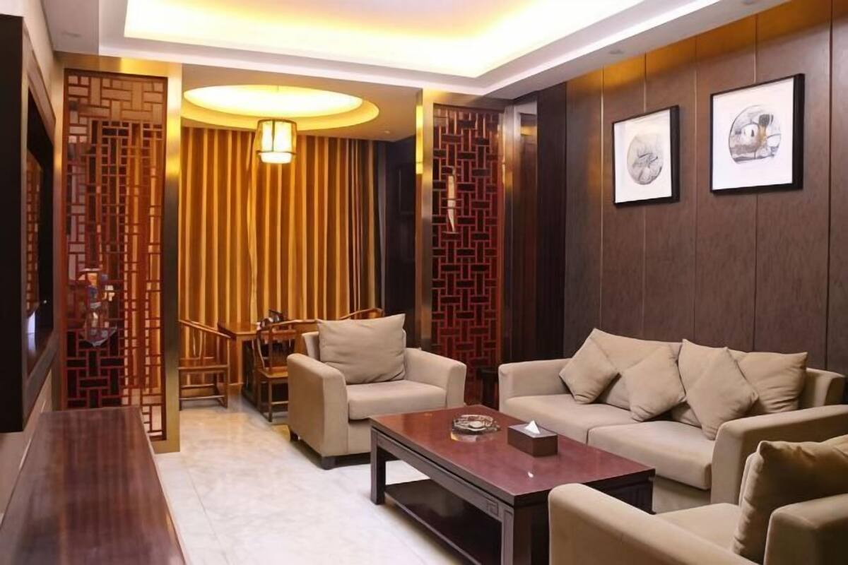 A living room with a sofa set, a coffee table, a TV, and a dining area with a table and chairs.
