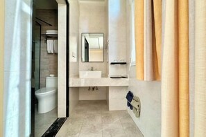 A modern bathroom with a glass shower enclosure, a white sink, and a mirror above it. - Noah Hotel (Chengjiang)