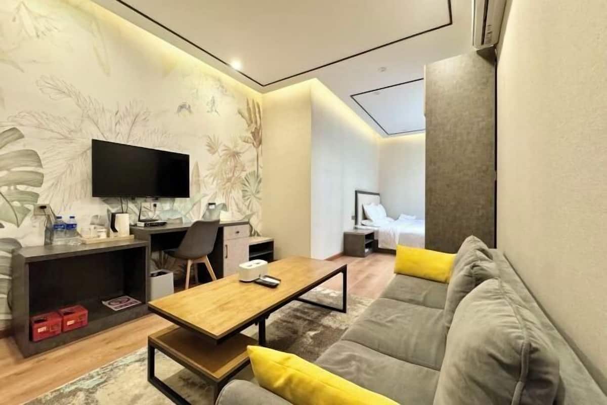 Ein modernes Wohnzimmer mit Sofa, Couchtisch und Fernseher.