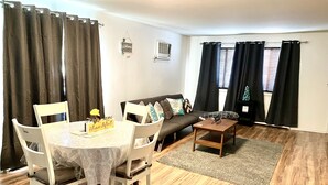 A living room with a dining table, chairs, a sofa, and a coffee table. - Homey, Cheerful & Spacious🙂 (Clifton)