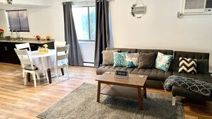 A modern living room with a sofa, a coffee table, and a dining area with a table and chairs. - Homey, Cheerful & Spacious🙂 (Clifton)