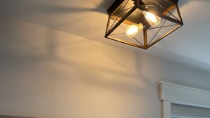 Een muur met een houten welkomsteken en een geometrisch lamp.