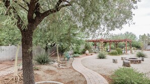 A garden with a curved brick pathway, a wooden pergola, and various plants. - Private Vegas Executive Home 15 Min To Strip Quiet Neighborhood (Las Vegas)