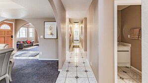 A hallway with a tiled floor, a wooden door, and a white wall. - Private Vegas Executive Home 15 Min To Strip Quiet Neighborhood (Las Vegas)