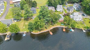 Vue aérienne d’un quartier résidentiel avec des maisons, un quai et un lac.