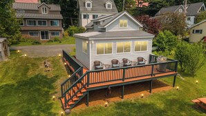 Une maison à deux étages dotée d’une terrasse, d’un espace salon extérieur et d’un escalier menant à la terrasse.