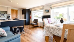 A compact living space with a kitchenette, a dining area, and a seating area with a view of the street.