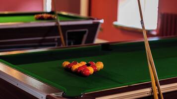 A pool table with balls arranged in a triangle formation, a pool cue, and a green felt surface.