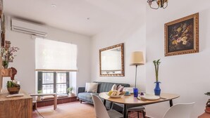 A modern living room with a sofa, dining table, chairs, and a large window. - Enjoy the magic of Triana Sevilla, Calle Castilla (Sevilla)