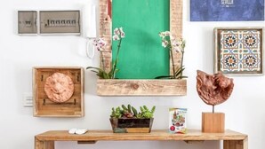 A wooden console table with a rustic design, a framed artwork, a potted plant, and a decorative sculpture. - Enjoy the magic of Triana Sevilla, Calle Castilla (Sevilla)