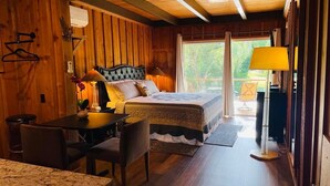 Una habitación estilo cabaña de madera con una cama, un escritorio y una silla.