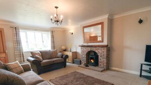 A living room with a fireplace, sofa, and a television. - Cherry Garth (Whitby)