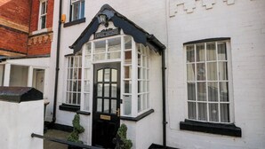 Una tradizionale cottage Rydal con una porta nera, finestre a cornice bianca e facciata in mattoni.