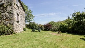 A stone building with a grassy yard and a picnic table. - Little Trespettigue (Launceston)