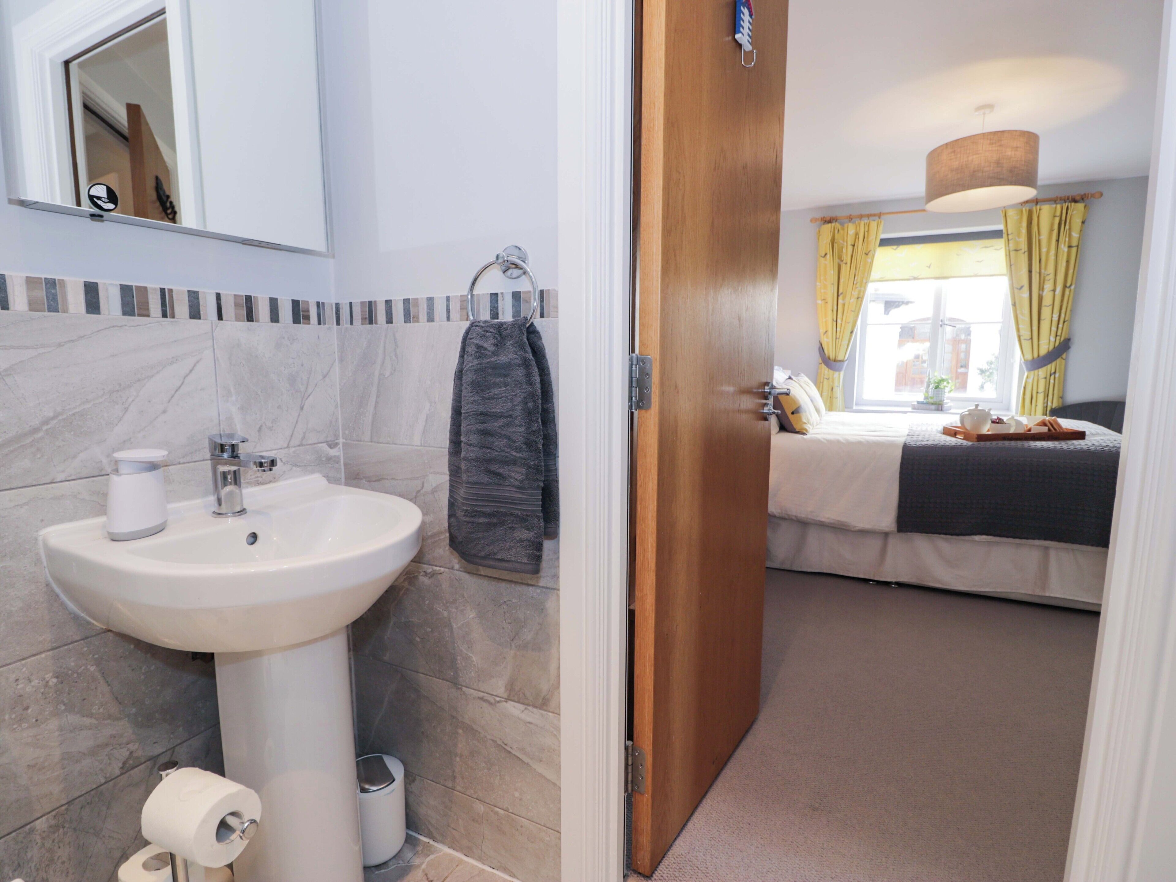 A bathroom with a sink, toilet, and towel rack.