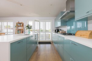 Una cocina moderna con armarios color turquesa, una encimera blanca y una isla central.