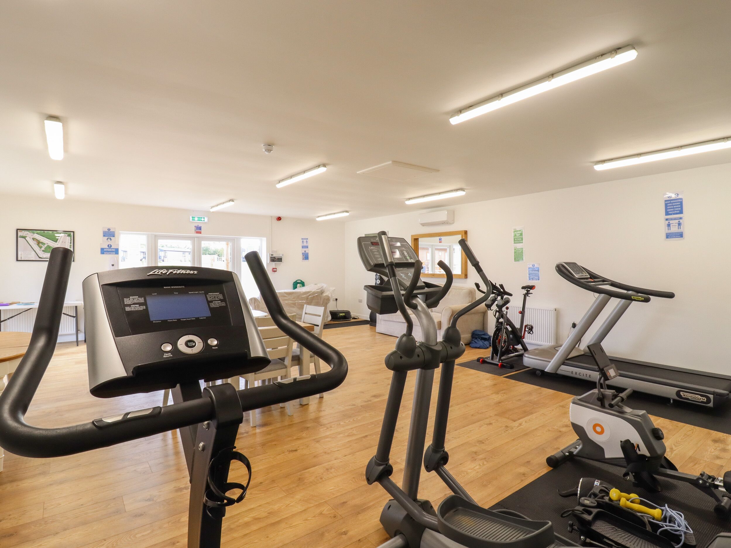 A gym with various exercise machines, including treadmills and elliptical trainers.