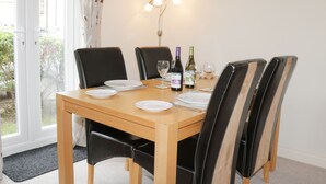 Une table à manger avec quatre chaises, une bouteille de vin et des verres.