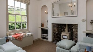 Una habitación con chimenea, un ventanal grande y un espejo encima.