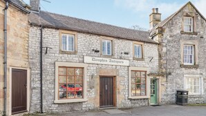 A stone building with a sign reading "Dauphin Antiques." - Dales Croft Apartment (Buxton)