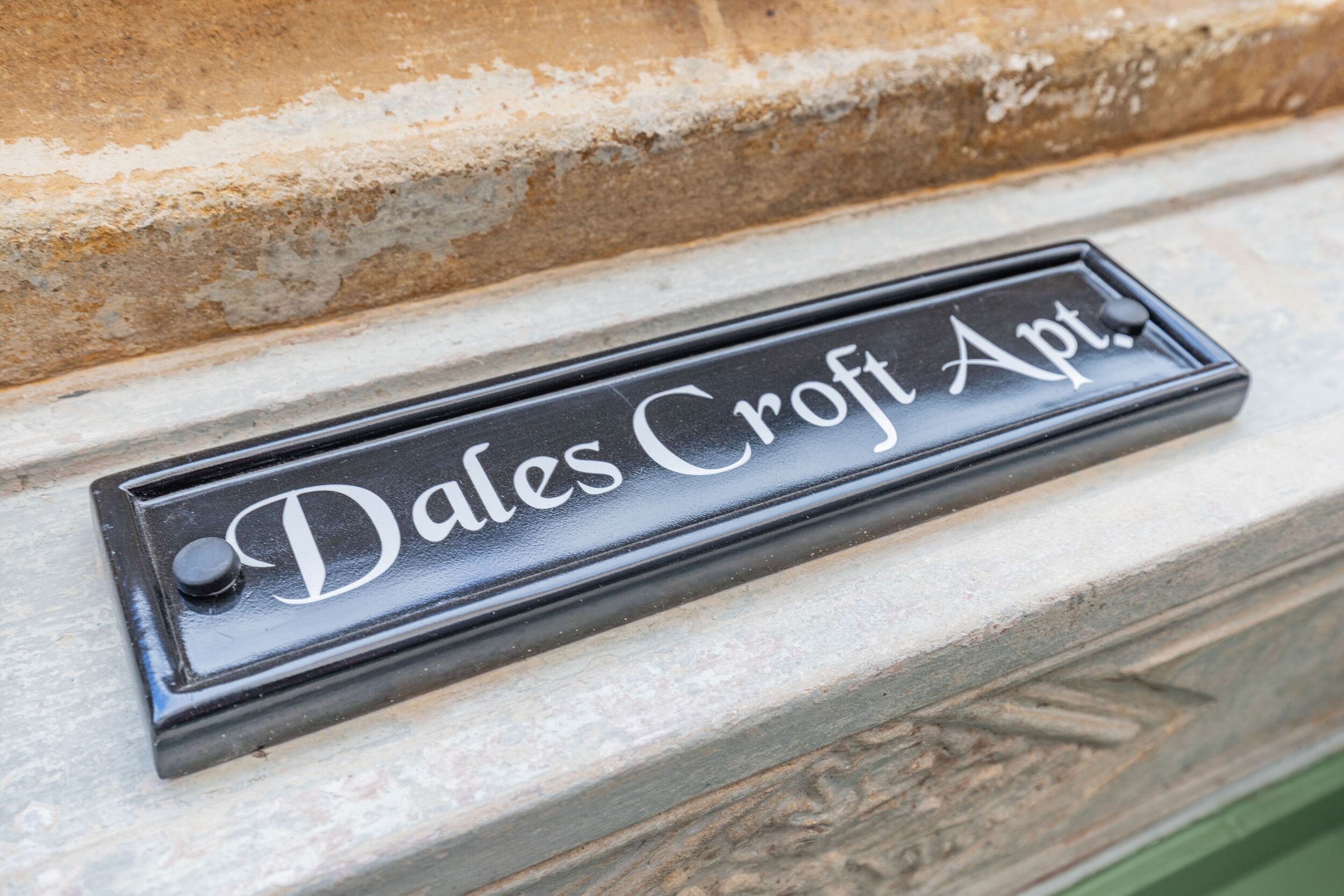 A black metal mailbox with the inscription "Dales Croft Apt."