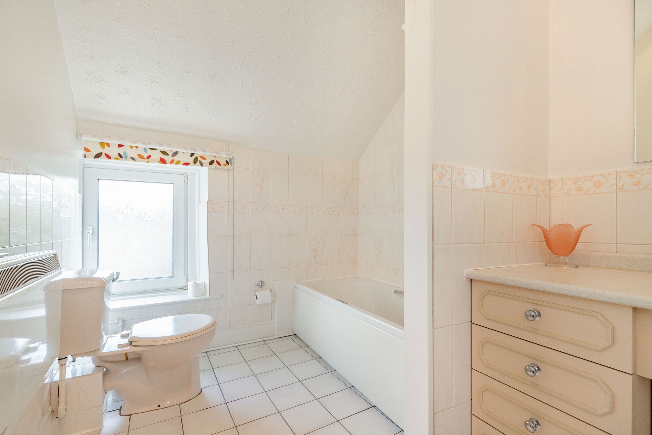 Une salle de bain comprenant des toilettes, une baignoire et un meuble-lavabo avec des tiroirs.