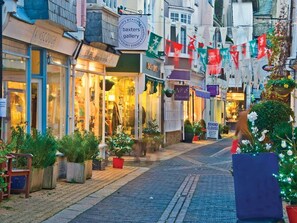 Rua repleta de lojas, incluindo uma joalheria e uma boutique.