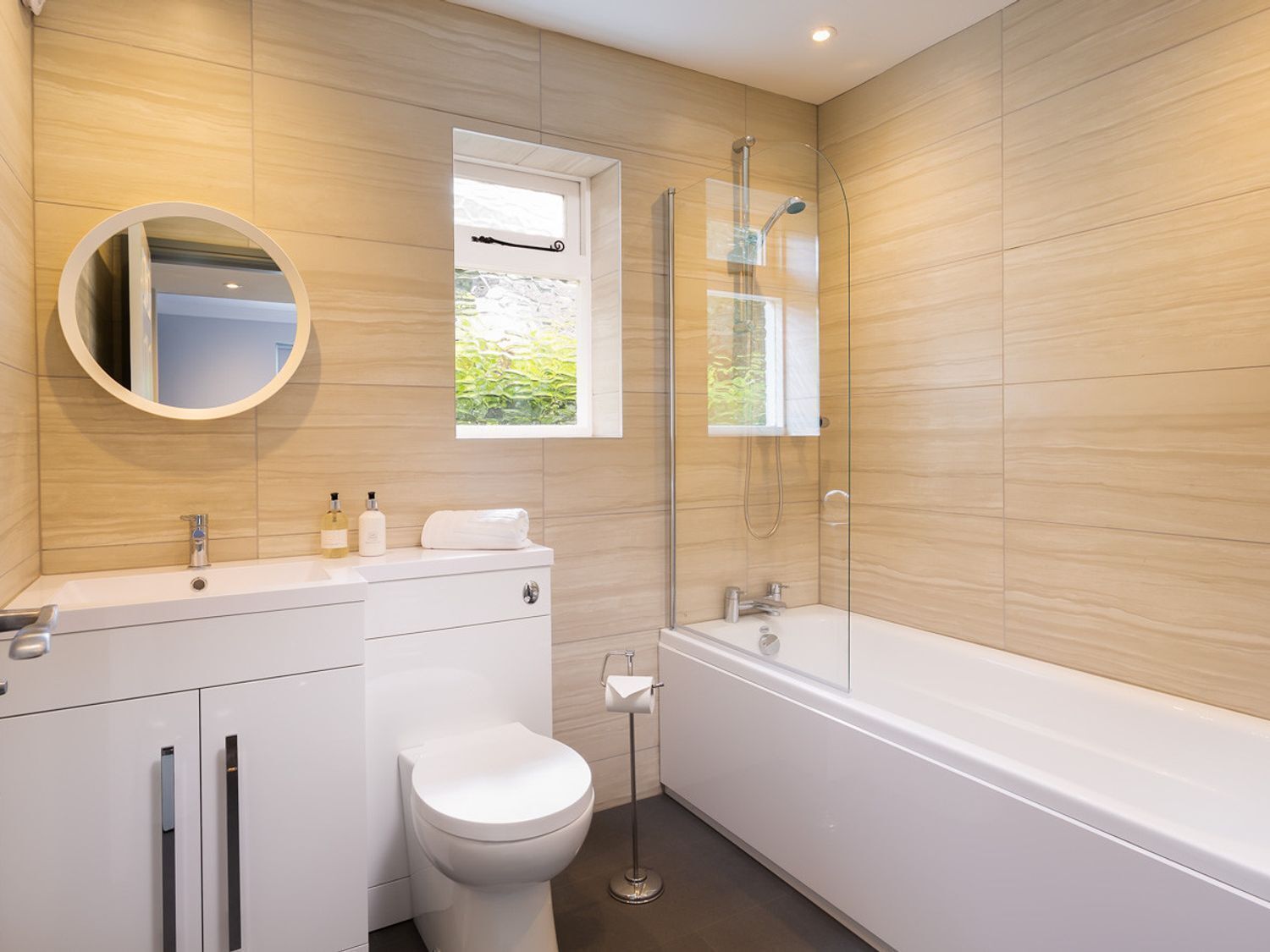 A modern bathroom with a toilet, sink, and bathtub.