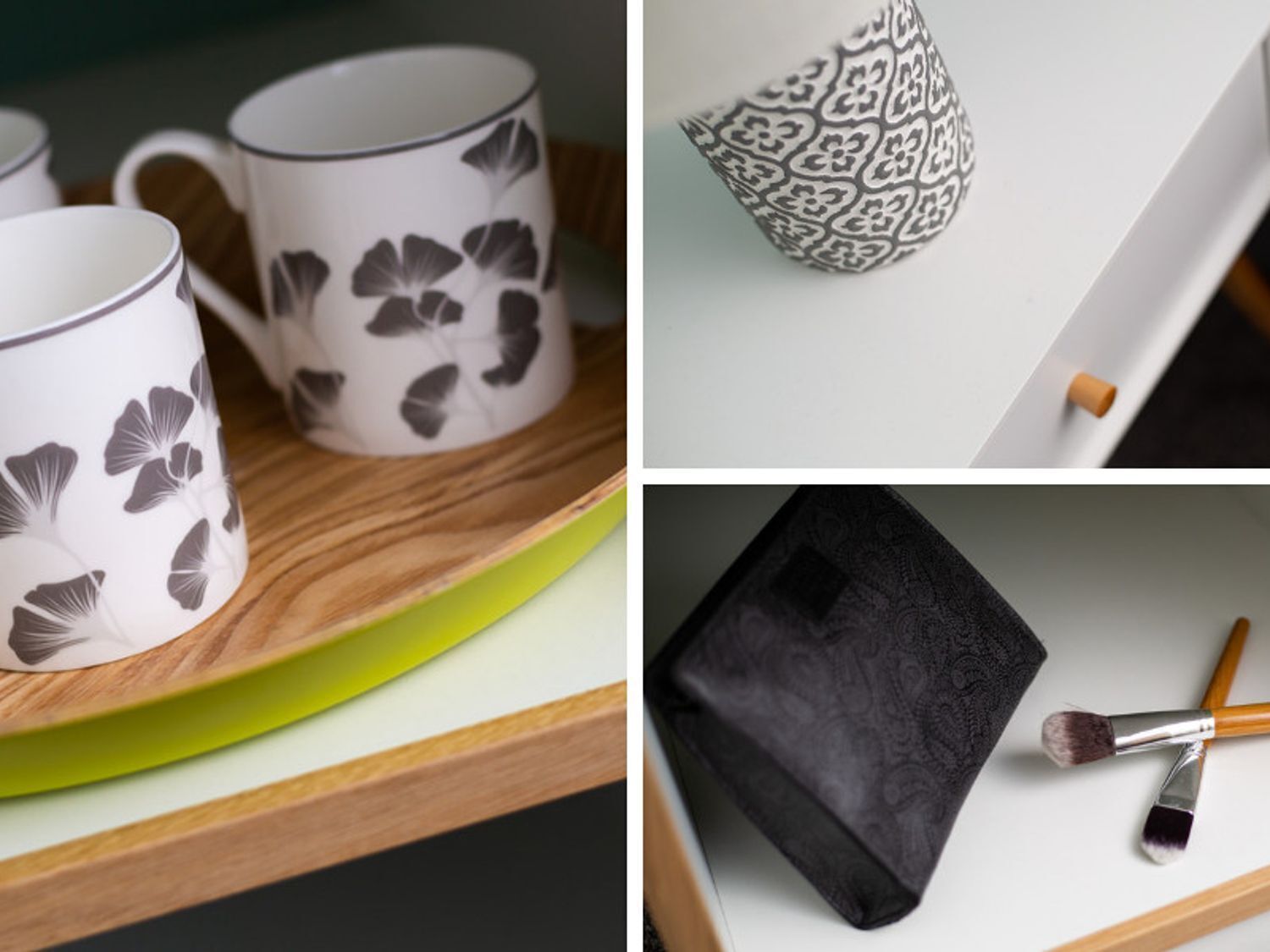 A set of white mugs with a floral pattern, a black and white patterned vase, and a black makeup case with brushes on a wooden surface.