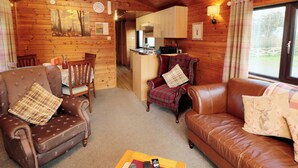 A cozy cabin interior with a living room, dining area, and kitchen. - Holly Lodge (Saltburn-by-the-Sea)