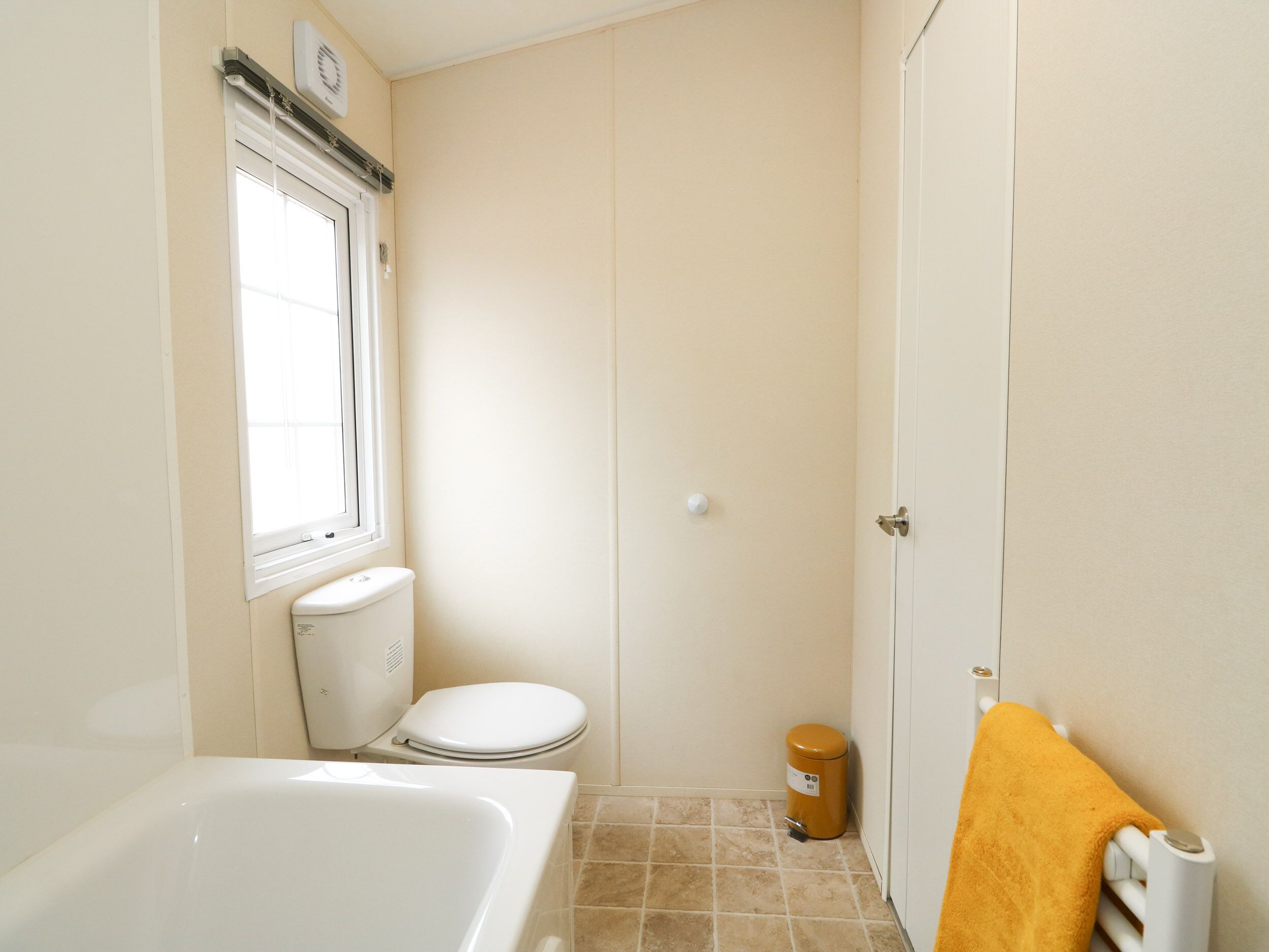A small, clean bathroom with a toilet, a sink, and a bathtub.