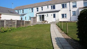 A residential building with a paved pathway leading to the entrance.