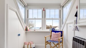 Une pièce confortable avec une fenêtre, une chaise, un radiateur et un lit.