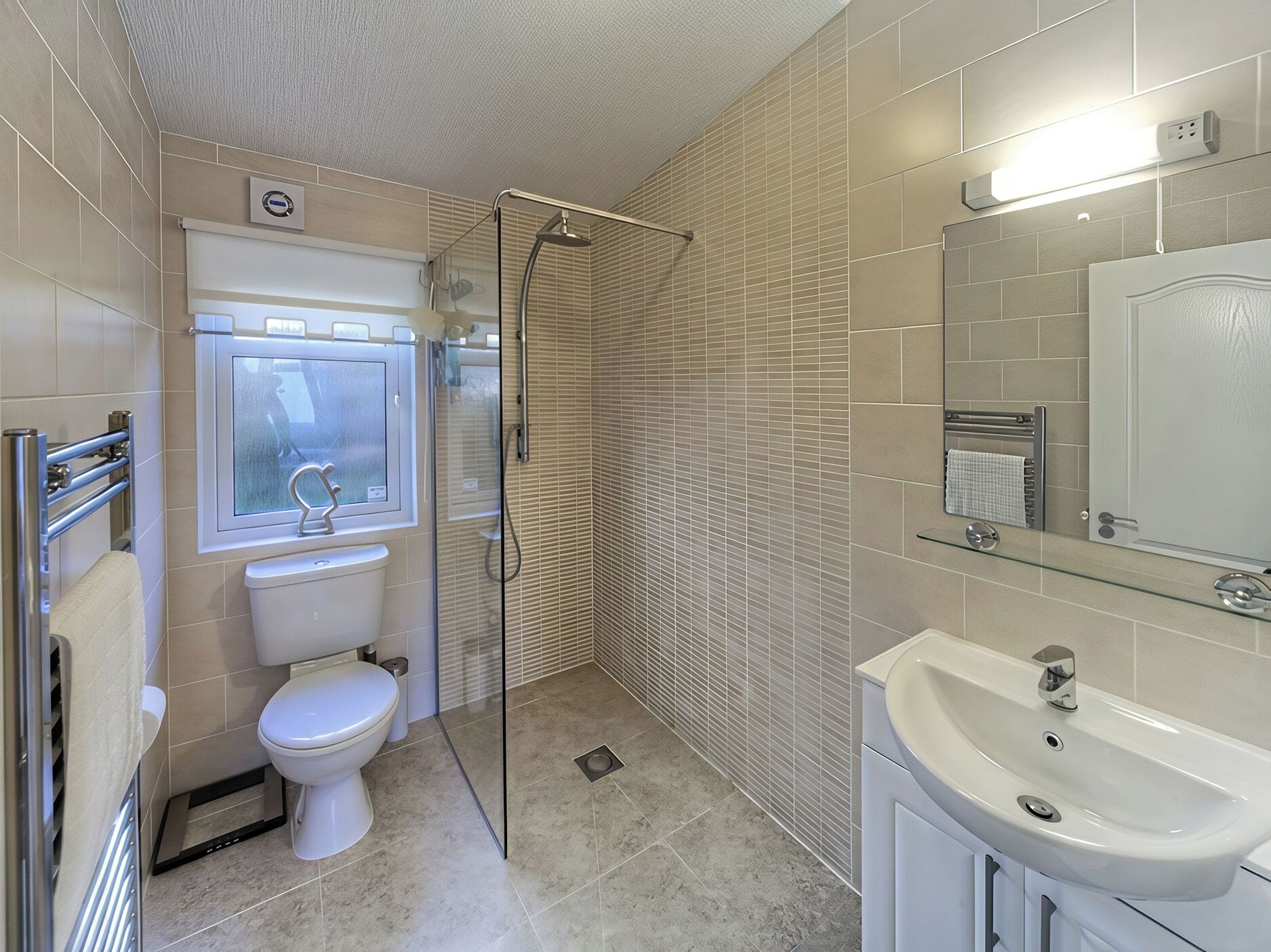 A modern bathroom with a toilet, shower, and sink.
