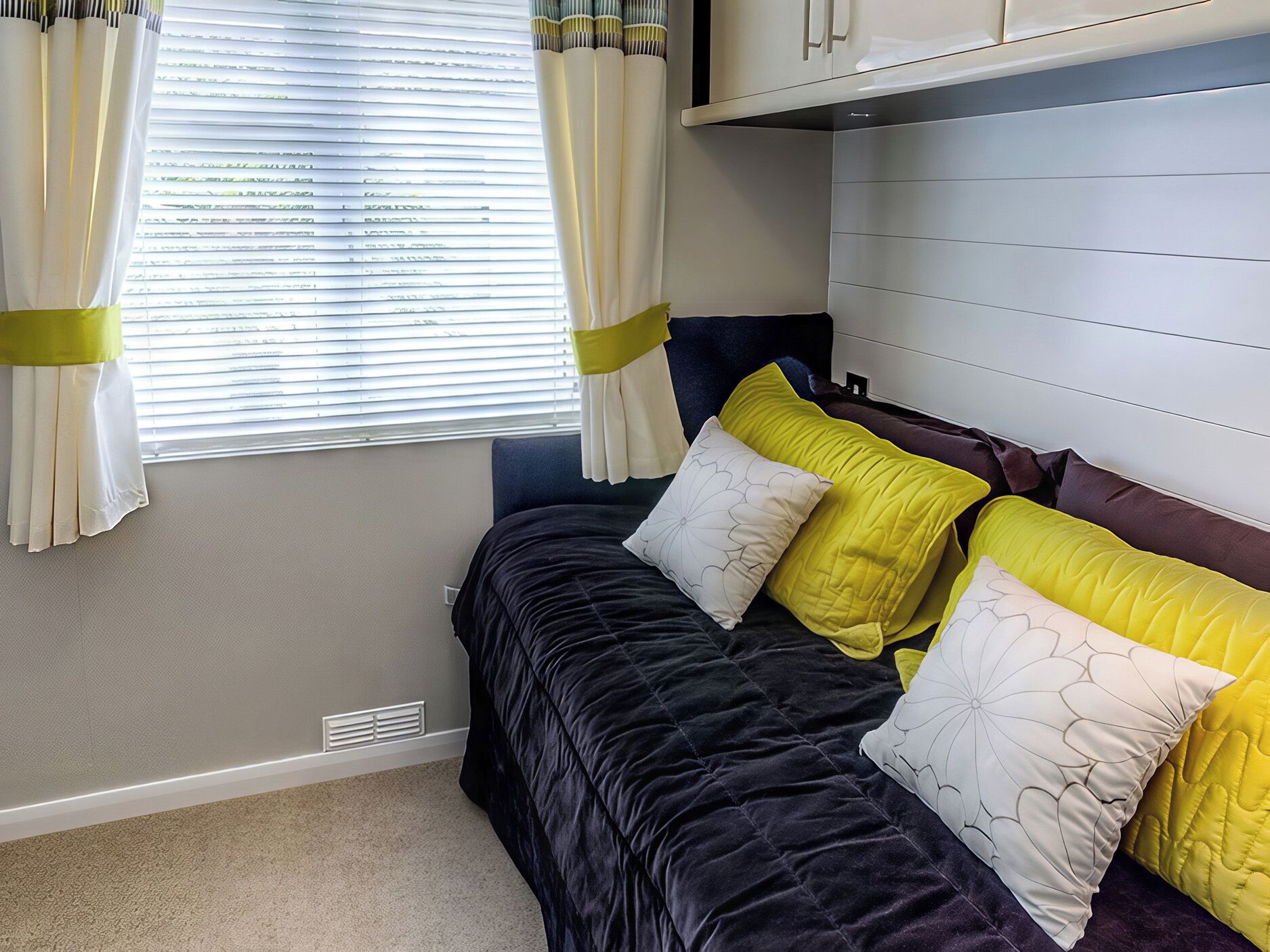 A bedroom with a bed, curtains, and a window.