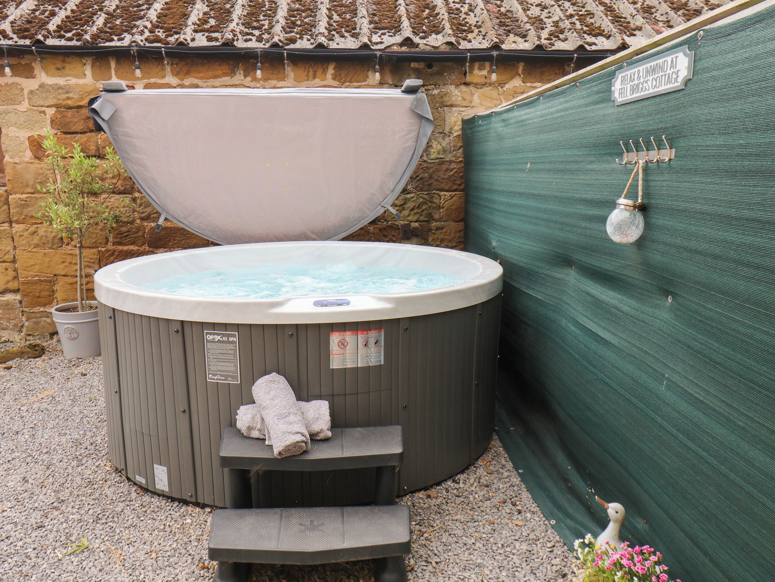 Un jacuzzi de spa con tapa, una toalla y un cartel que indica una zona de relajación.