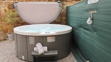 Un jacuzzi de spa con tapa, una toalla y un cartel que indica una zona de relajación.